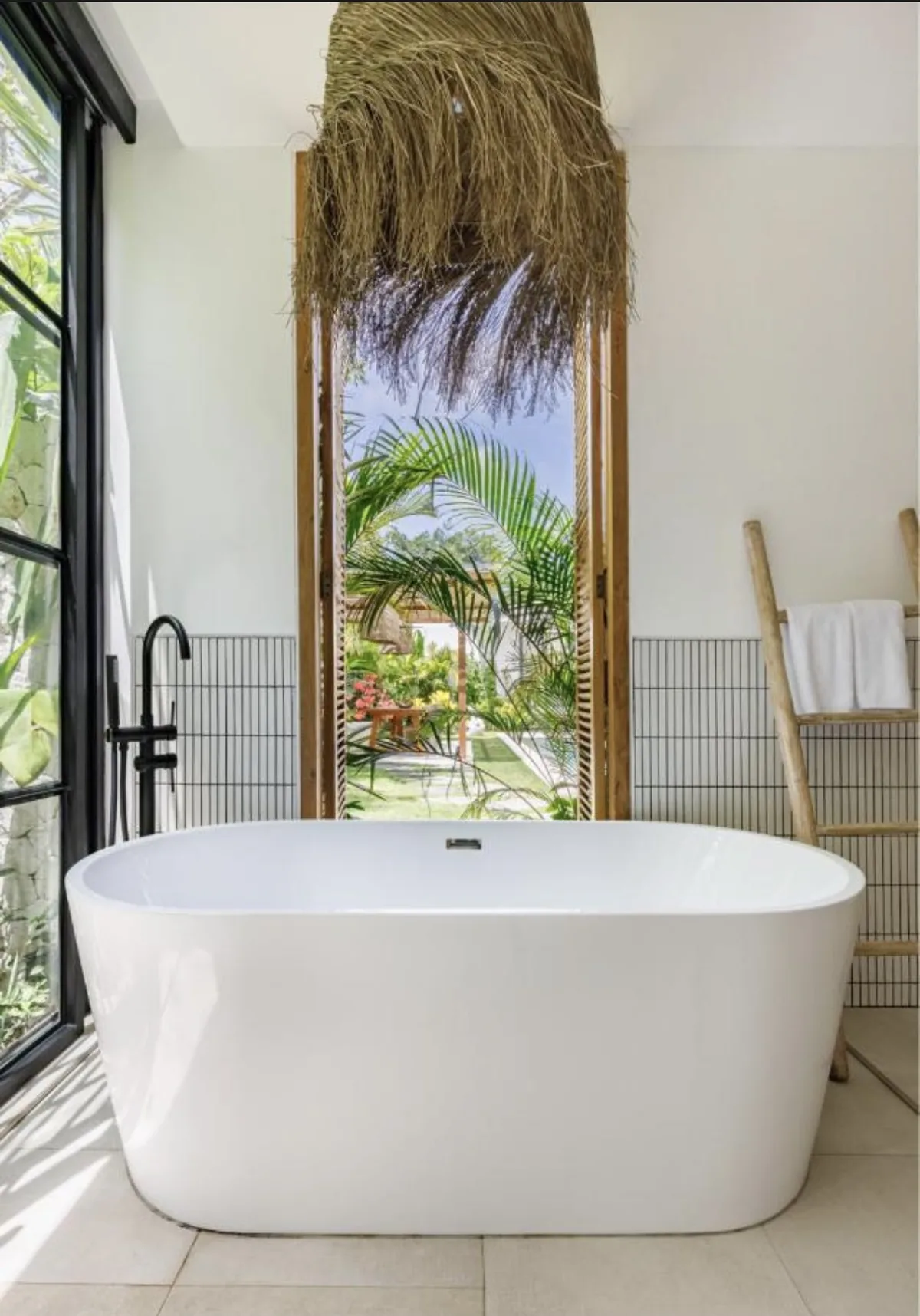 Salle de bain de la villa avec baignoire et vue sur la végétation